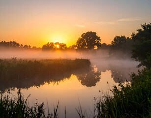 Fototapeta premium Serene Sunrise Misty River Reflections at Dawn