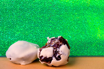 Chocolate dates with bites and alone, bright green background is very much in demand