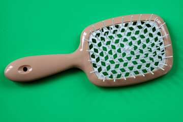 A women's hairbrush on a bright green background, ideal for product images. Its comfortable design and vibrant color scheme make it an attractive element for advertising or a catalog.
