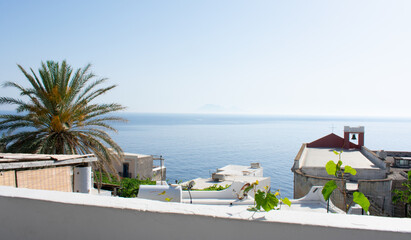 Obraz premium Patio view of houses, church, and sea in Ginostra, Italy