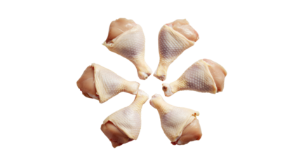 Raw chicken drumsticks arranged in a flower pattern, white isolated background.
