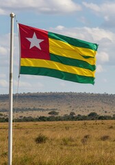 Waving Togolese Flag Representing West African Heritage Over the Rolling Savanna Hills Landscape