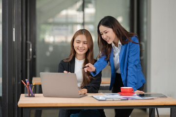 Two young female businesswomen are meeting in an office