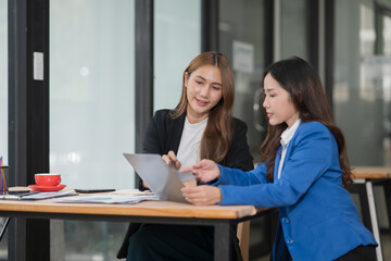 Two young female businesswomen are meeting in an office
