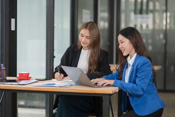 Two young female businesswomen are meeting in an office