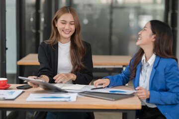 Two young female businesswomen are meeting in an office.
