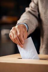 Hand of a person putting ballot paper in the voting box, Person casting vote into ballot box. Vote, Freedom democracy concept
