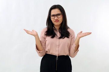 Young Asian woman standing with frowning expression, eyebrows raised, palms open to the side,...