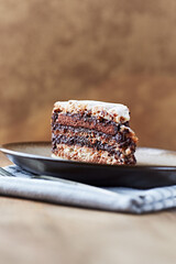 Piece of chocolate cake on rustic background. Close up.