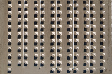 Perfect geometry of shadows and umbrellas on a deserted beach seen from above