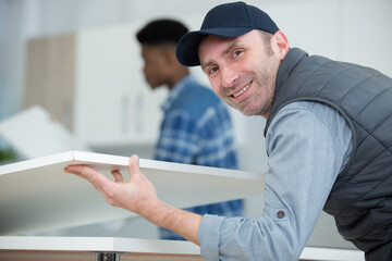two men assembling a kitchen cupboard
