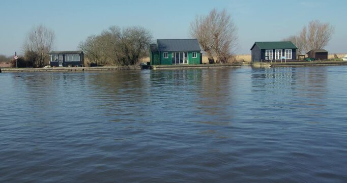 Wide shot of riverside cottage on the river Thurne at the village of Thurne