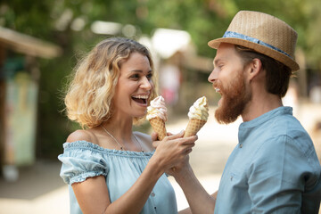 Fototapeta premium couple sharing ice cream while enjoying sunny weather outdoors