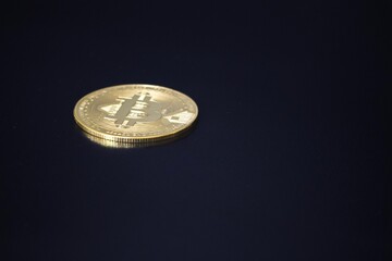 Golden Bitcoin isolated on black background. Symbol of cryptocurrency, blockchain technology, and digital financial innovation. 