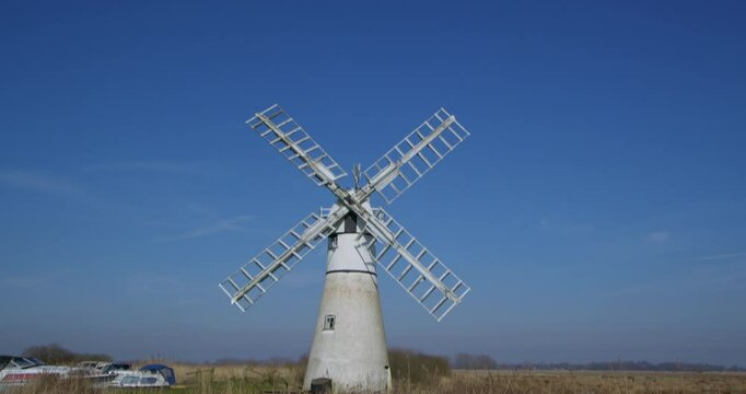 Wide shot tilting down Thurne mill, on the river Thurne,