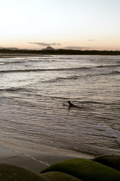 Young girl surfing at sunset