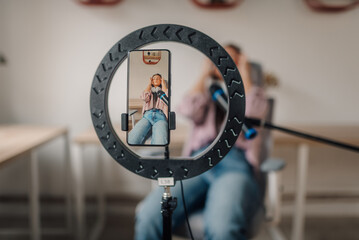 Content creator recording a video with a ring light and microphone
