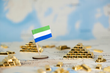 Sierra Leone flag stands on world map surrounded by shiny gold bars, representing the nation's rich...