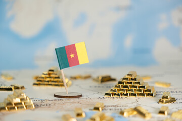 Cameroon flag on world map with stacked gold bars, symbolizing national wealth and natural...