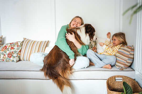 Mother and daughter enjoying time with their dog at home