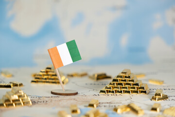 Ivorian flag with miniature gold bars on map symbolizing Ivory Coast's mineral wealth, gold export...