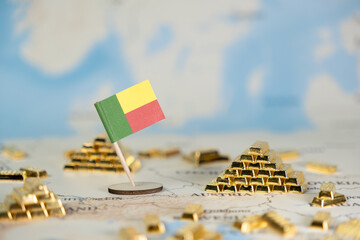 Benin flag surrounded by gold bar piles on a world map signifies national wealth, global...