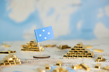 Micronesia flag on a world map with numerous gold bar stacks, representing global economy, finance,...
