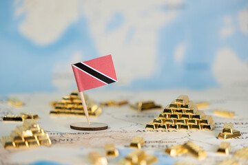 Trinidad and Tobago flag stands with golden bar pyramids on global map, illustrating national...