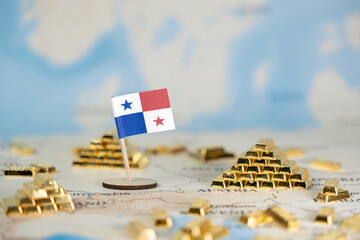 Panama's flag and abundant gleaming gold bars on a world map, signifying national economic...
