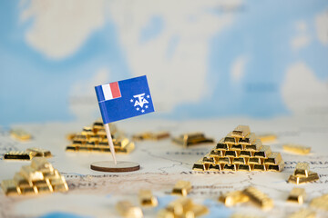 Miniature flag of French Southern and Antarctic Lands on a global map with numerous gold bars,...