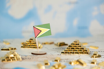 Guyana flag alongside shining gold bars on a world map, representing national wealth, natural...