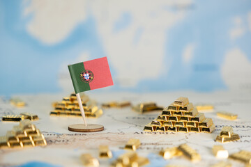 Naklejka premium Portuguese flag on a world map surrounded by gold bars, symbolizing national wealth, economic stability, and global financial market influence, with copy space