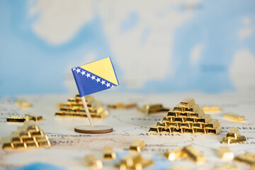 Bosnia and Herzegovina flag and gold bars on a map, symbolizing national wealth, economic...