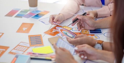 Team of Designers Collaborating. Professionals discussing layout concepts and color selections at a creative workspace.