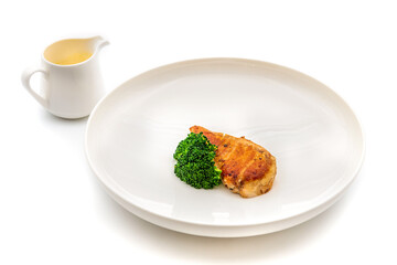 Grilled chicken breast with broccoli and sauce on a white porcelain plate