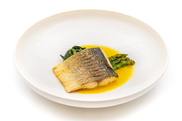 Grilled sea bass fillet served with garnishes in a fine dining restaurant