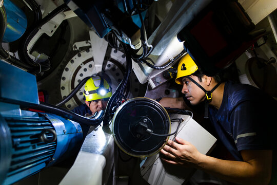 Engineers performing maintenance on a wind turbine nacelle rotor indoors