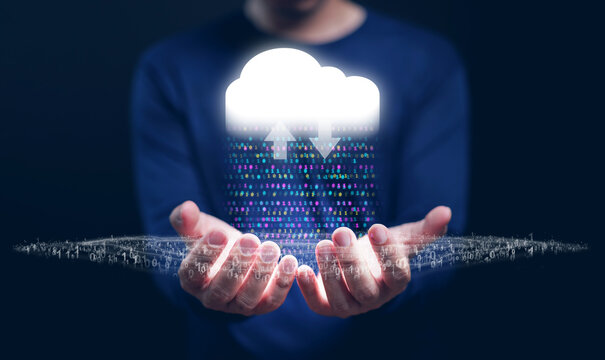 Cloud Computing Concept – A man with cloud technology in his hand delivering IT resources as binary code via the Internet with data streams, networking, and datum management fortTech and digital trans