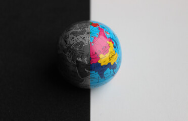 Asian Continent on Small Globe with Trade Routes Splitted with Straight Border on Colored and Grayscale Parts. Globe Split in Color on a Border Between Black and White Surfaces over Asia