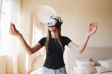Young woman engages in virtual reality experience indoors while exploring a modern living space in natural light
