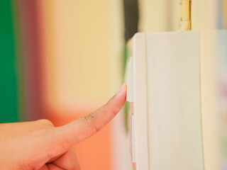 Closeup woman's fingers turning off light switch in an office or at home. The hand of person closed...