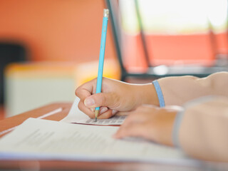 Closeup of hands female of students taking exams in a classroom, exams in school, writing and...