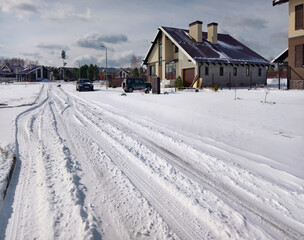 Snow covered, uncleared road in a siberian cottage village after Spring snowfall.