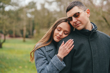 Obraz premium Couple enjoying a tender moment in a tranquil park setting during springtime