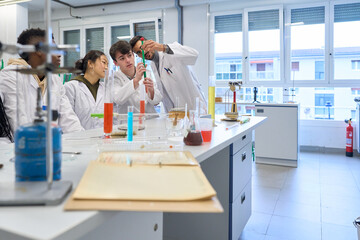 Students and teacher doing chemical experiment in laboratory