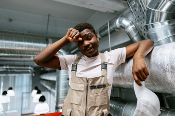 Worker resting in industrial space after a long day of labor, showcasing relaxation and...