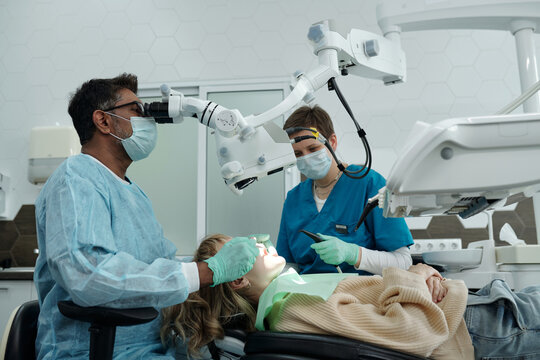 Dentist and Assistant Treating Patients Teeth