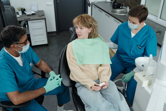 Young Woman Talking to Dentist After Cavity Treatment