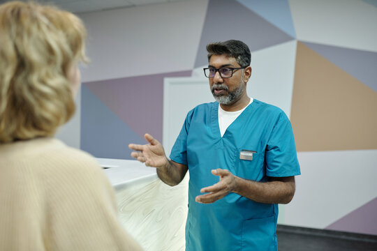 Doctor Talking to Patient While Standing in Hospital Hall