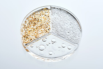 A three-section petri dish with textures of various cosmetic serums.